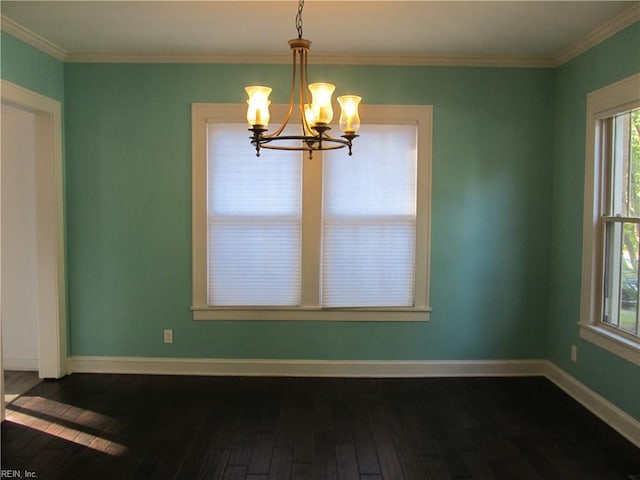 unfurnished dining area featuring wood-type flooring, ornamental molding, and an inviting chandelier