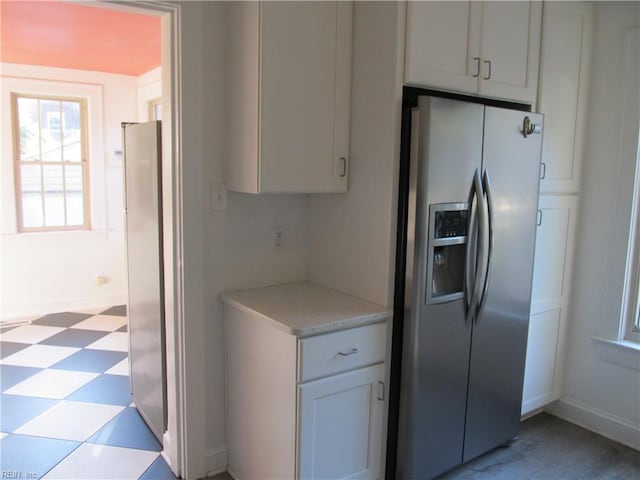 kitchen featuring white cabinets and stainless steel fridge