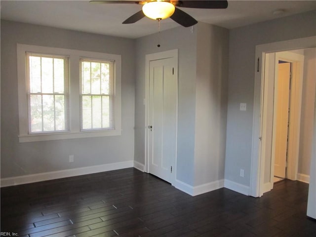 unfurnished bedroom featuring dark wood-type flooring, a closet, and ceiling fan