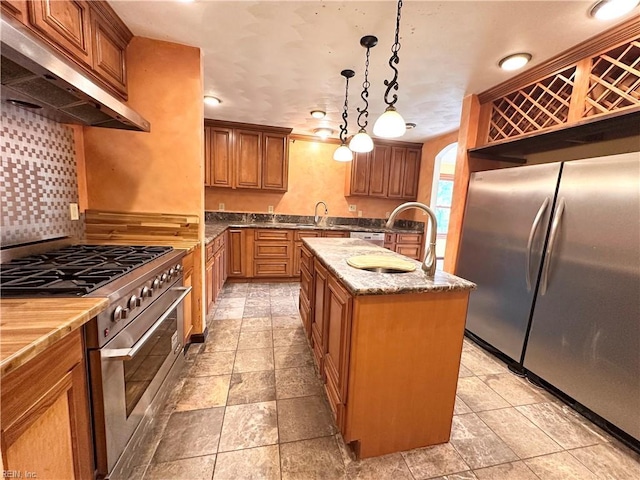 1057 W Rd, Chesapeake, VA 23323 - kitchen with appliances with stainless steel finishes, extractor fan, an island with sink, brown cabinetry, and a sink