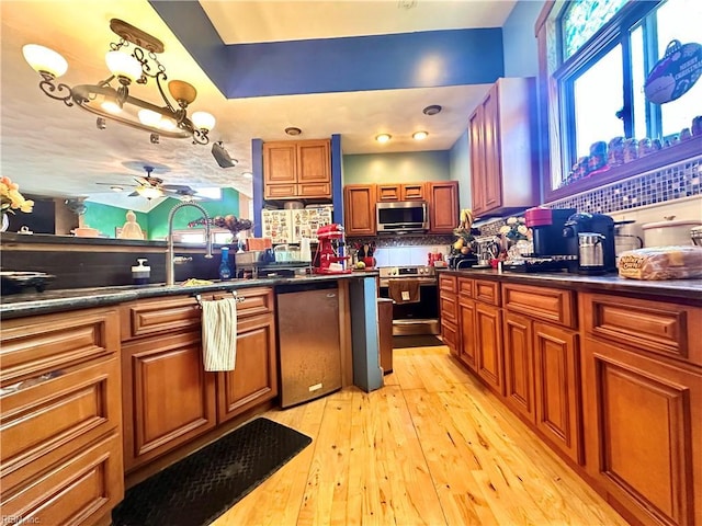 1057 W Rd, Chesapeake, VA 23323 - kitchen with stainless steel appliances, dark countertops, backsplash, light wood-style floors, and brown cabinets