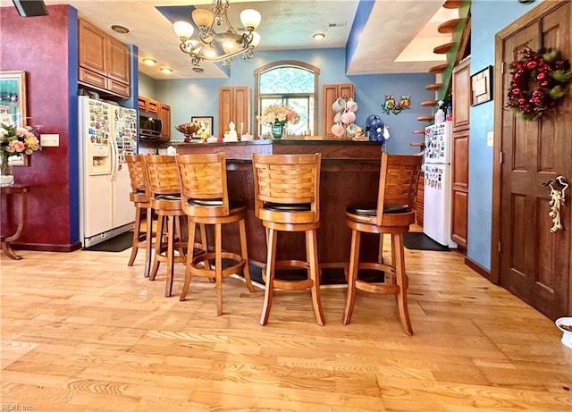 1057 W Rd, Chesapeake, VA 23323 - bar area with white fridge with ice dispenser, light wood-style flooring, stainless steel microwave, a chandelier, and pendant lighting