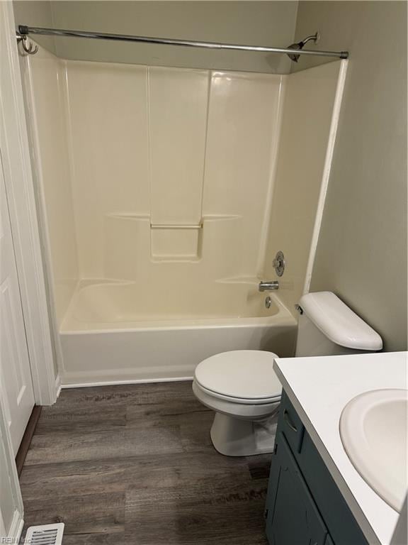 full bathroom featuring toilet, hardwood / wood-style floors, vanity, and washtub / shower combination