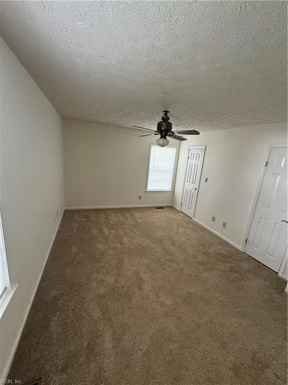 carpeted empty room featuring a textured ceiling and ceiling fan