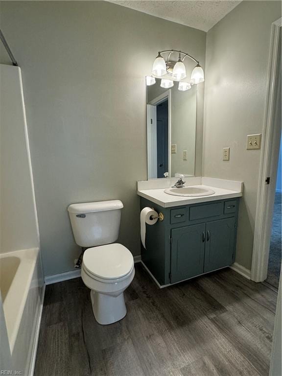 full bathroom featuring vanity, toilet, wood-type flooring, and a textured ceiling