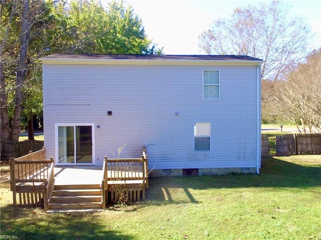 back of house featuring a wooden deck and a lawn