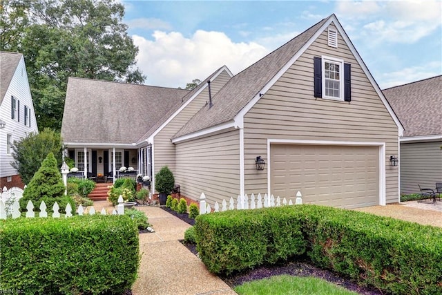 cape cod home featuring a porch and a garage