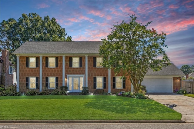 view of front of home with a garage and a lawn