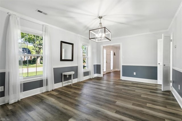 unfurnished living room with ornamental molding, a notable chandelier, and dark hardwood / wood-style flooring