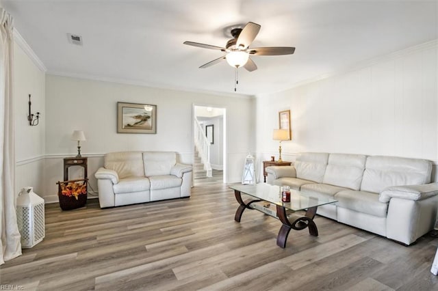 living room with ornamental molding, hardwood / wood-style flooring, and ceiling fan