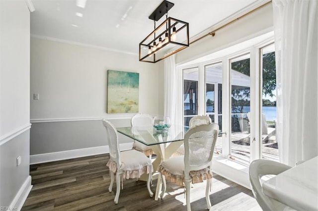 dining space featuring an inviting chandelier, ornamental molding, and dark hardwood / wood-style flooring