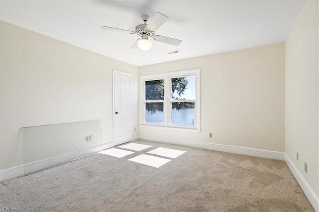 carpeted spare room featuring ceiling fan