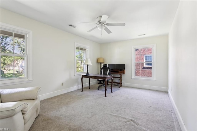 carpeted office featuring a wealth of natural light and ceiling fan