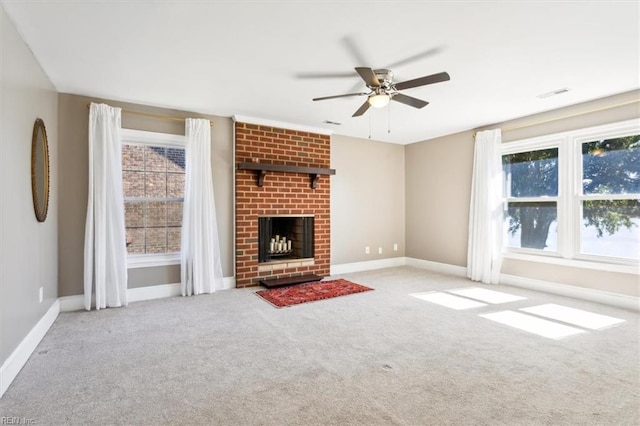 unfurnished living room with light carpet, a brick fireplace, plenty of natural light, and ceiling fan