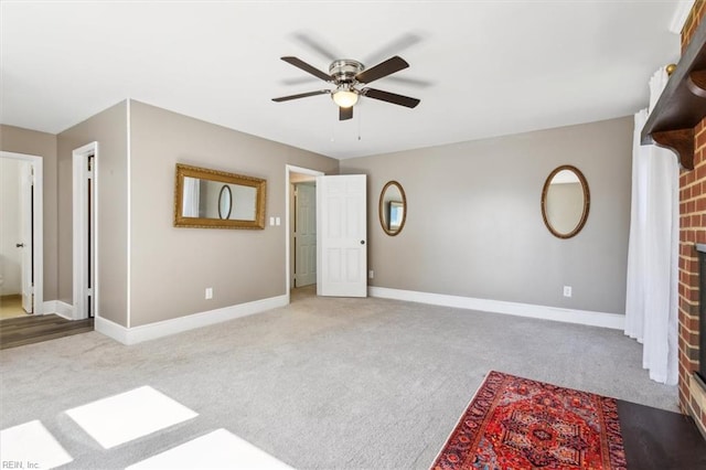 interior space with a brick fireplace, ceiling fan, and light colored carpet