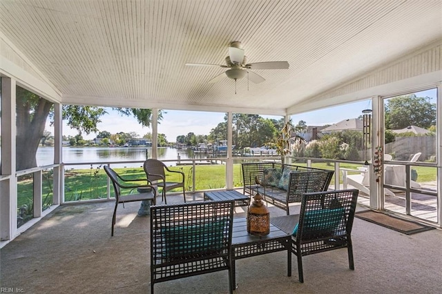 sunroom / solarium with a water view, vaulted ceiling, and ceiling fan