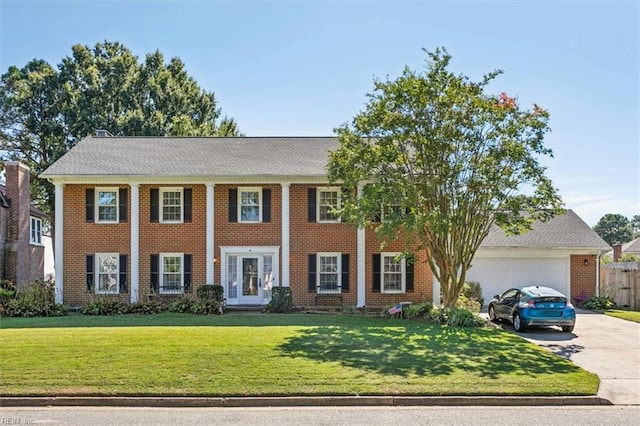 colonial home with a garage and a front lawn