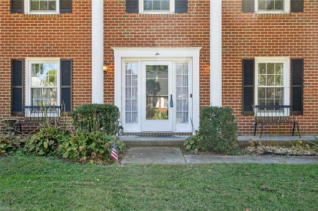 doorway to property featuring a lawn