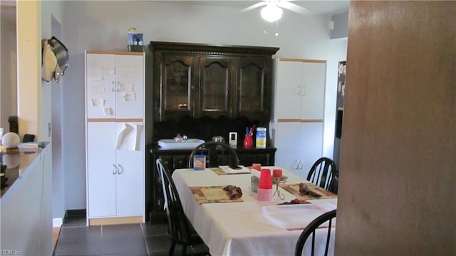 tiled dining room featuring ceiling fan and sink