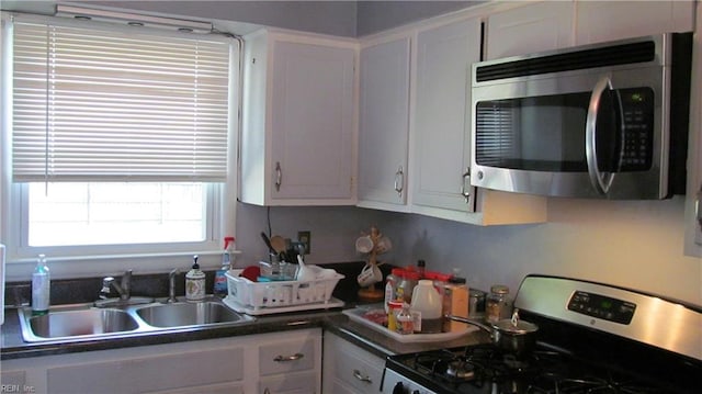 kitchen featuring stainless steel appliances, sink, and white cabinetry