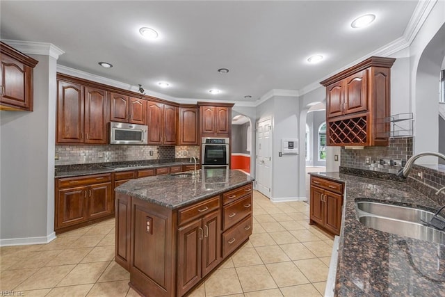 kitchen featuring crown molding, sink, light tile patterned floors, and stainless steel appliances