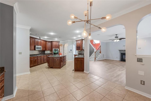 kitchen featuring a kitchen island, decorative backsplash, stainless steel appliances, decorative light fixtures, and ornamental molding