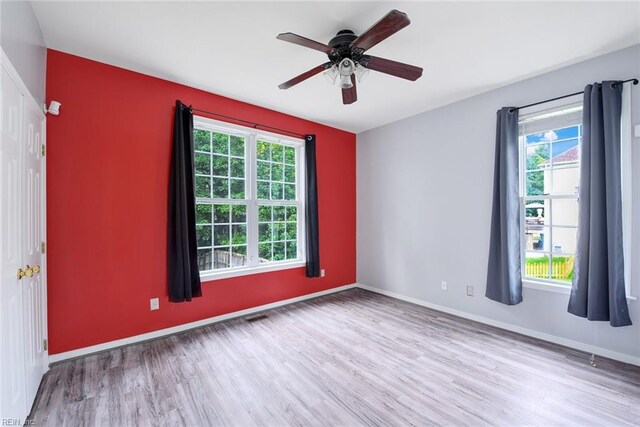 spare room featuring ceiling fan, plenty of natural light, and light hardwood / wood-style floors