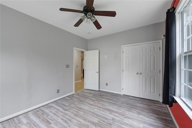 unfurnished bedroom featuring ceiling fan, a closet, and light hardwood / wood-style floors