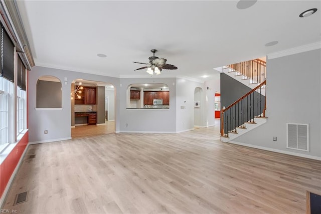 unfurnished living room with light wood-type flooring, ornamental molding, and ceiling fan