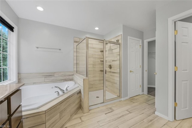 bathroom with plus walk in shower and hardwood / wood-style flooring