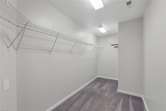 spacious closet featuring dark carpet