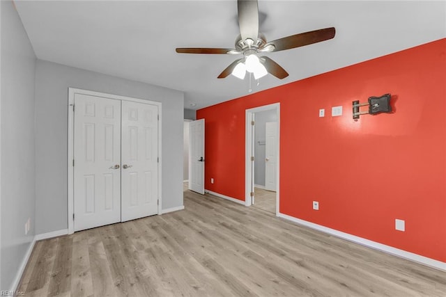 unfurnished bedroom with a closet, light wood-type flooring, and ceiling fan