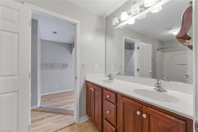 bathroom featuring wood-type flooring, vanity, and walk in shower