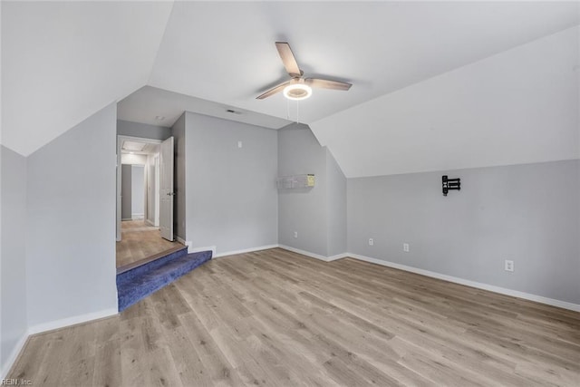 additional living space with light hardwood / wood-style floors, vaulted ceiling, and ceiling fan