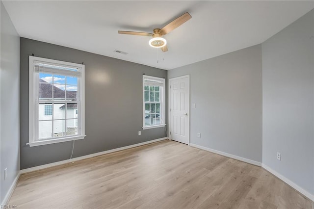 empty room with ceiling fan and light hardwood / wood-style flooring