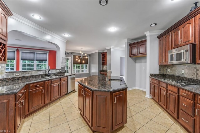 kitchen featuring ornamental molding, sink, stainless steel appliances, and decorative light fixtures