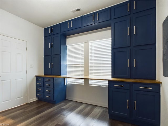 kitchen with dark wood-type flooring and blue cabinetry