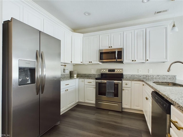 kitchen with white cabinets, sink, appliances with stainless steel finishes, light stone countertops, and dark hardwood / wood-style flooring