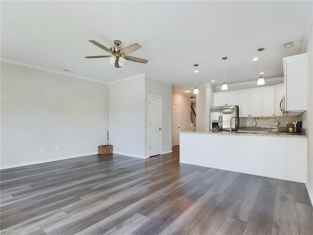 kitchen featuring light stone counters, dark hardwood / wood-style floors, stainless steel refrigerator with ice dispenser, white cabinetry, and hanging light fixtures