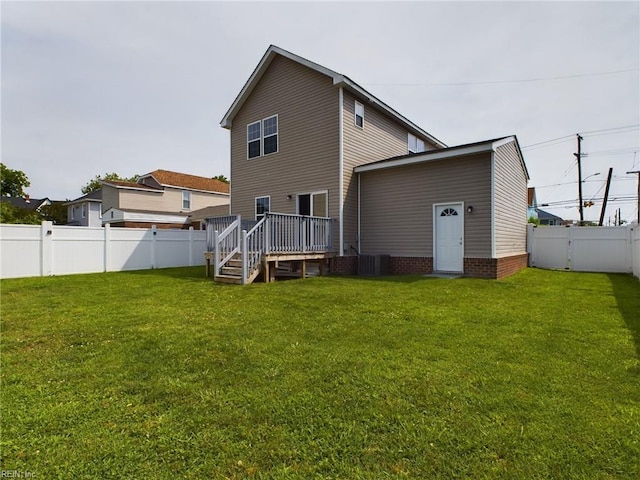 rear view of property with a lawn, central air condition unit, and a wooden deck