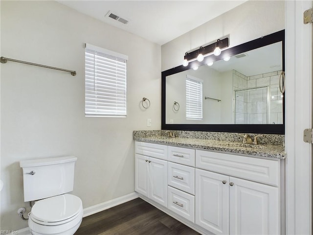 bathroom with vanity, a shower with shower door, toilet, and hardwood / wood-style flooring