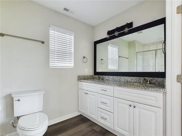 bathroom with vanity, wood-type flooring, a shower with shower door, and toilet