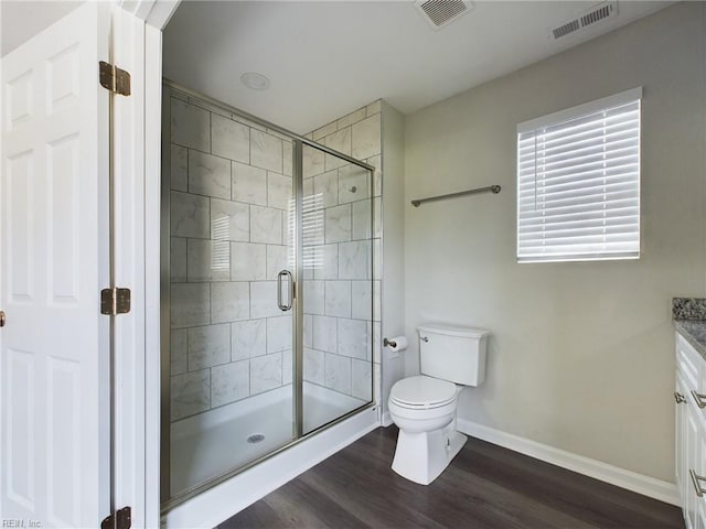 bathroom featuring wood-type flooring, vanity, toilet, and an enclosed shower