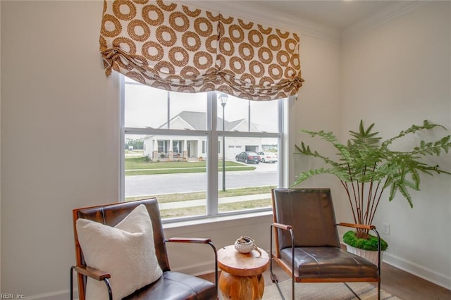 sitting room with hardwood / wood-style flooring and ornamental molding