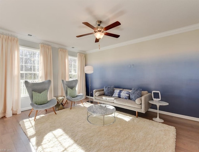 living room with wood-type flooring, crown molding, and ceiling fan