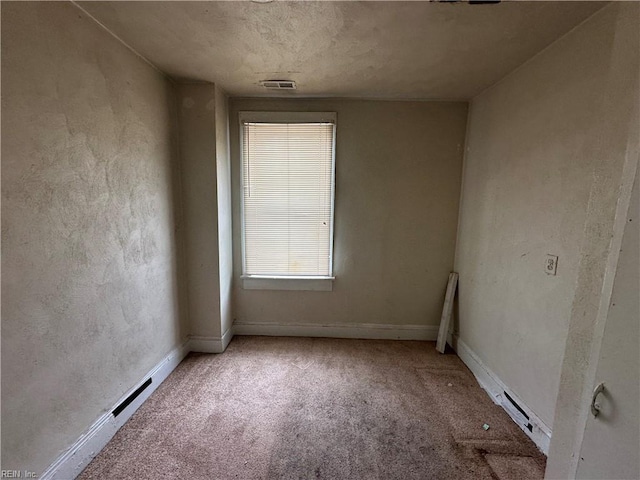 carpeted spare room featuring baseboard heating