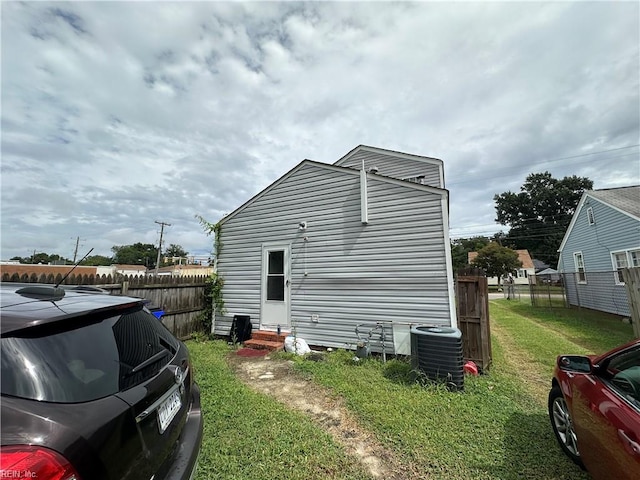 view of side of property featuring a yard and cooling unit