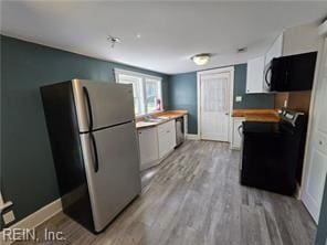 kitchen with white cabinets, black appliances, and light wood-type flooring