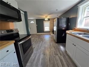 kitchen featuring appliances with stainless steel finishes, white cabinets, ceiling fan, hardwood / wood-style flooring, and sink