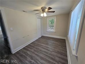 unfurnished room with dark hardwood / wood-style flooring and ceiling fan